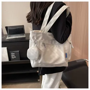Side view of white tote bag worn by model, showing large capacity and coin purse