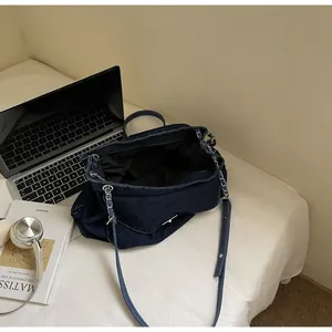 Interior view of large capacity dark blue denim shoulder bag with chain strap