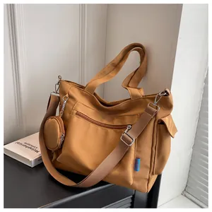 Detailed view of a large brown canvas tote bag with a small coin pouch and straps.