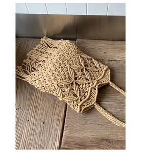 Detailed view of a bohemian hand-woven beige macrame tote bag with stylish fringe accents.