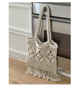 Chic cream macrame tote bag with fringe tassels hanging in a minimalist home kitchen