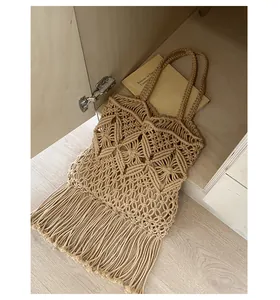 Detailed close-up of hand-woven macrame tote bag featuring elegant long fringe tassels