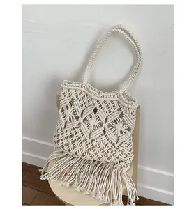 Detail view of cream macrame woven tote bag featuring hollow knit and long tassels