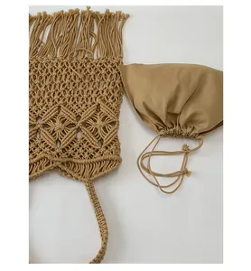 Macro view of handmade khaki macramé tote bag with fringe and matching drawstring pouch.