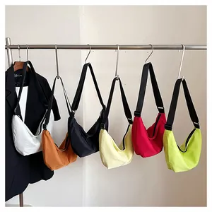 Colección de bolsos bandolera minimalistas de colores colgados en un perchero