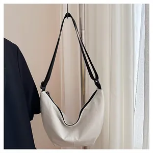 Bolso de media luna blanco minimalista de gran capacidad colgado en un soporte de metal