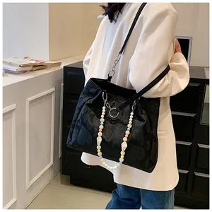 Sweet black jacquard tote bag with colorful bead chain shown on a model in white blazer