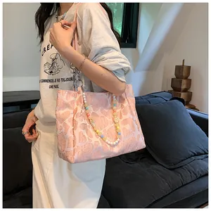 Fashionable pink heart-patterned tote bag with a decorative colorful beaded chain strap