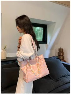Stylish pink heart pattern tote bag with colorful beaded strap shown in lifestyle setting