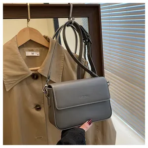 Detail view of a vintage minimalist grey square crossbody bag with silver hardware
