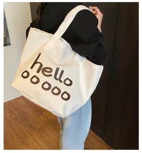 Vista detallada del bolso tote de lona blanca con diseño de letras Hello en color marrón
