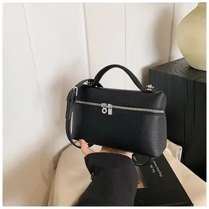 Bolso de mano negro de cuero PU con asa superior y detalle de cremallera plateada.