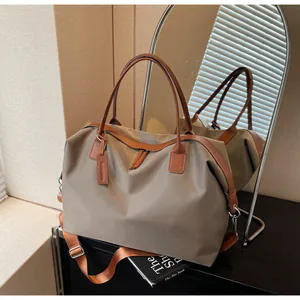 Large capacity khaki travel bag with brown leather straps and metal zippers on desk