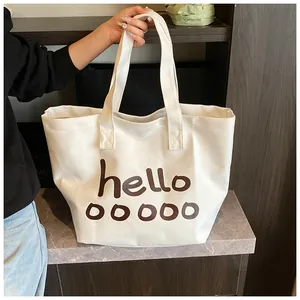 Bolso tote grande de lona blanca con estampado de letras 'hello' en un entorno de estilo de vida