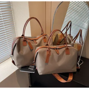 Close-up detail of two stylish khaki and brown large capacity travel duffel bags for sport