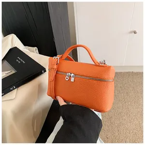 Primer plano de bolso naranja de cuero PU con elegante textura granulada y cremallera