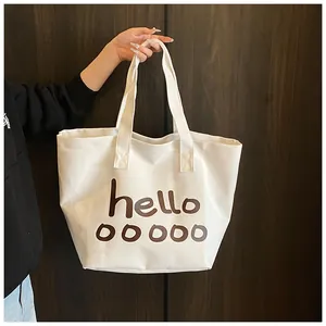 Primer plano detallado de bolso tote de lona blanca con estampado de letras hello marrón