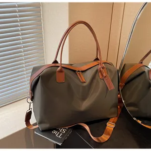 Large capacity olive green travel bag with brown leather straps shown in lifestyle setting