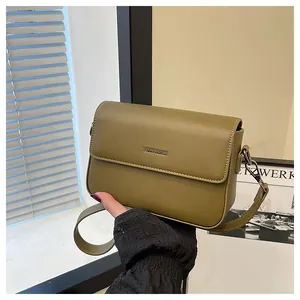 Close-up of olive green vintage minimalist square crossbody bag with metal logo