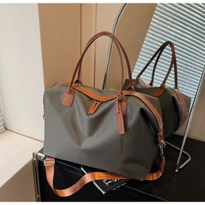 Detail of large dark olive travel duffel bag with brown leather straps and mirror reflection