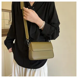 Close-up detail of a stylish olive green retro minimalist square crossbody bag on a model