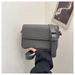 Detailed view of a gray minimalist square crossbody bag featuring Tommy Knight logo