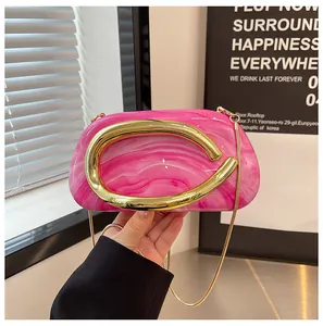 Detail of vintage pink marble patterned evening clutch with gold C-shaped metal handle.