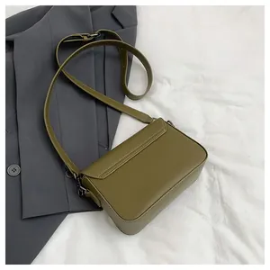 Detailed back view of olive green retro textured small square crossbody bag on blazer
