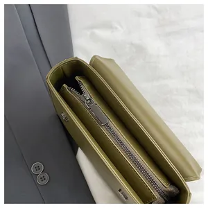 Detail of olive green vintage crossbody bag showing smooth zipper closure and interior