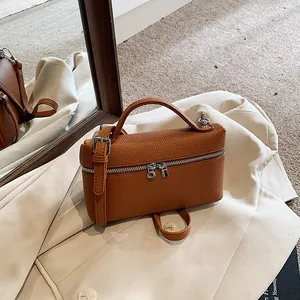 Modische Handtasche aus braunem PU-Leder mit Tragegriff und verstellbarem Riemen.