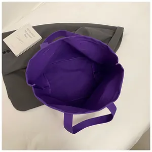 Vista interior que muestra la gran capacidad y el bolsillo del bolso de lona morado amplio.