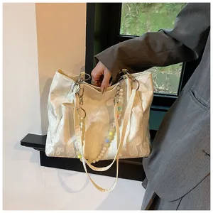 Detailed view of white floral jacquard tote bag with colorful beaded shoulder strap