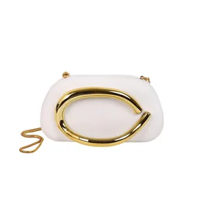 White evening clutch bag with oversized gold circular metal handle and chain strap