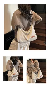 Detailed views of a minimalist beige canvas messenger bag worn by a model on stairs.