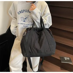 Zwarte nylon tote bag met trekkoord voor dames, minimalistische casual crossbody tas.