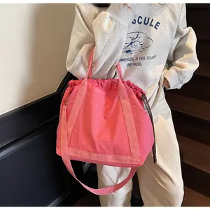Detailweergave van de roze nylon bucket bag met handig trekkoord en schouderband.