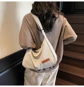 Minimalist large canvas messenger bag shown on model back view in staircase setting