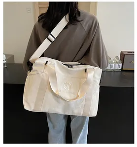 Grande borsa da viaggio bianco crema per donna indossata come borsa a tracolla