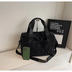Grande borsa da viaggio nera con texture stropicciata e telefono per scala dimensionale.
