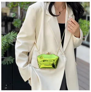 Detail view of a model carrying a vibrant neon green acrylic evening clutch with chain