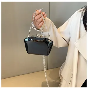 Detail of a chic black geometric acrylic evening clutch featuring a silver chain strap.