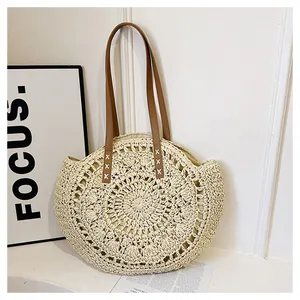 Macro view of the intricate round hollow flower weaving pattern on a casual straw beach bag