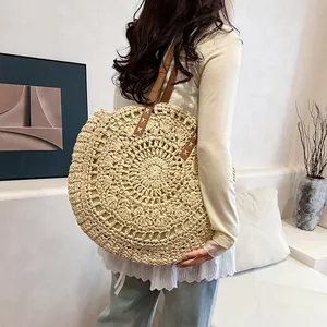 Large bohemian round hollow flower straw woven shoulder bag carried by female model