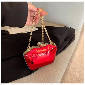 Detailed view of a trendy red lip-shaped acrylic clutch bag with a gold chain strap