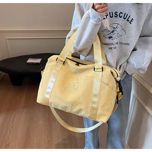 Dettaglio borsa da viaggio marmorizzata giallo chiaro con grande capacità e tracolla.