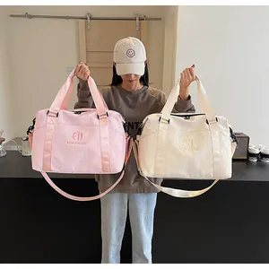 Donna che tiene due grandi borse da viaggio rosa e crema per il fitness o i viaggi.