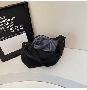 Detailed view of a minimalist black nylon crossbody bag showing its spacious interior