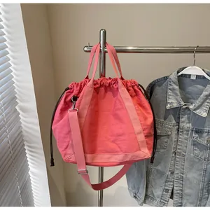 Gedetailleerd overzicht van de roze nylon emmer tas met trekkoord en riempjes