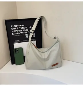 Close-up view of a minimalist large capacity grey messenger bag in a modern lifestyle setting