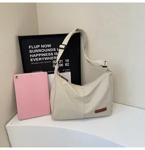 Minimalist off-white large capacity messenger bag shown with student lifestyle props.